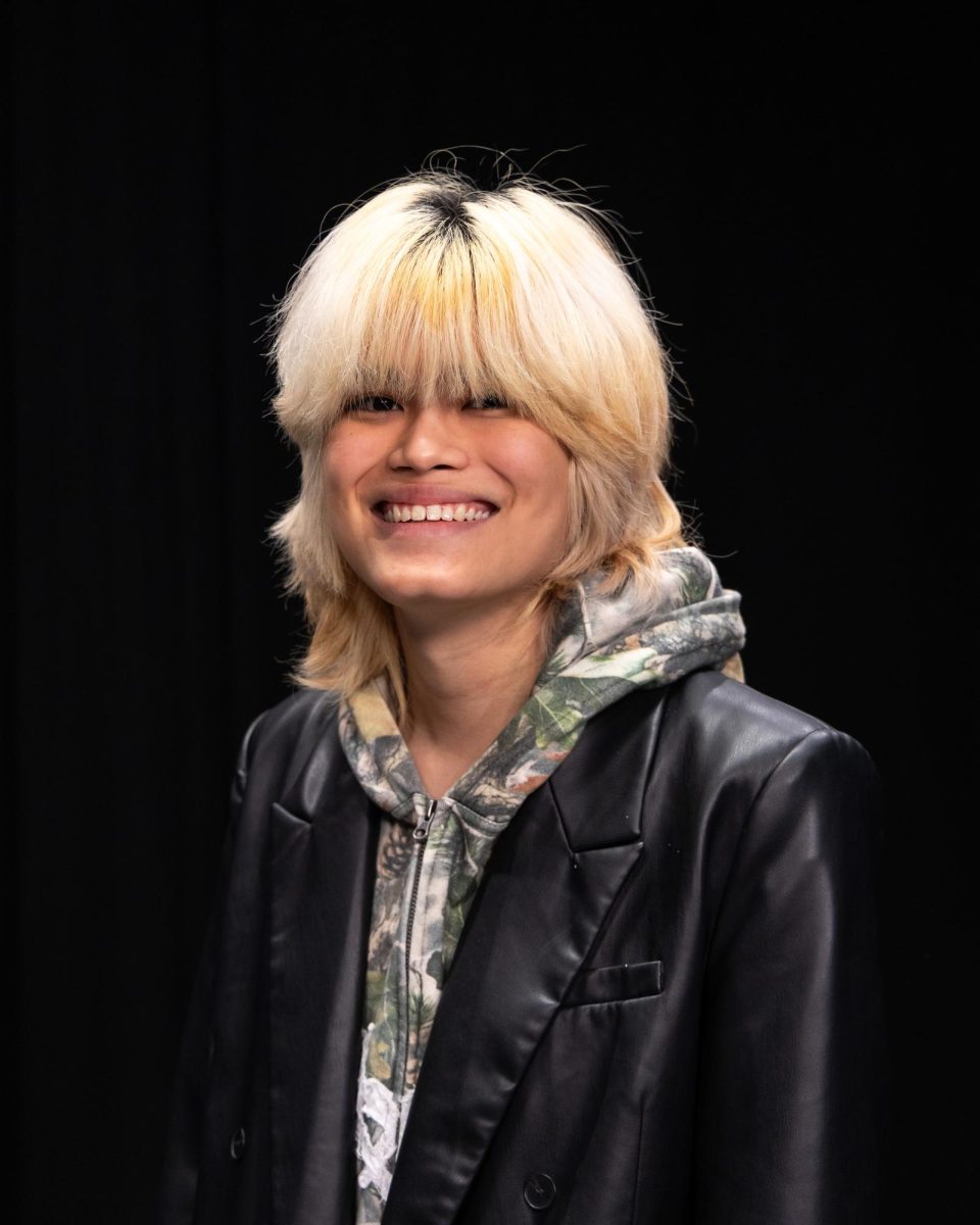 A person standing in front of a black background.