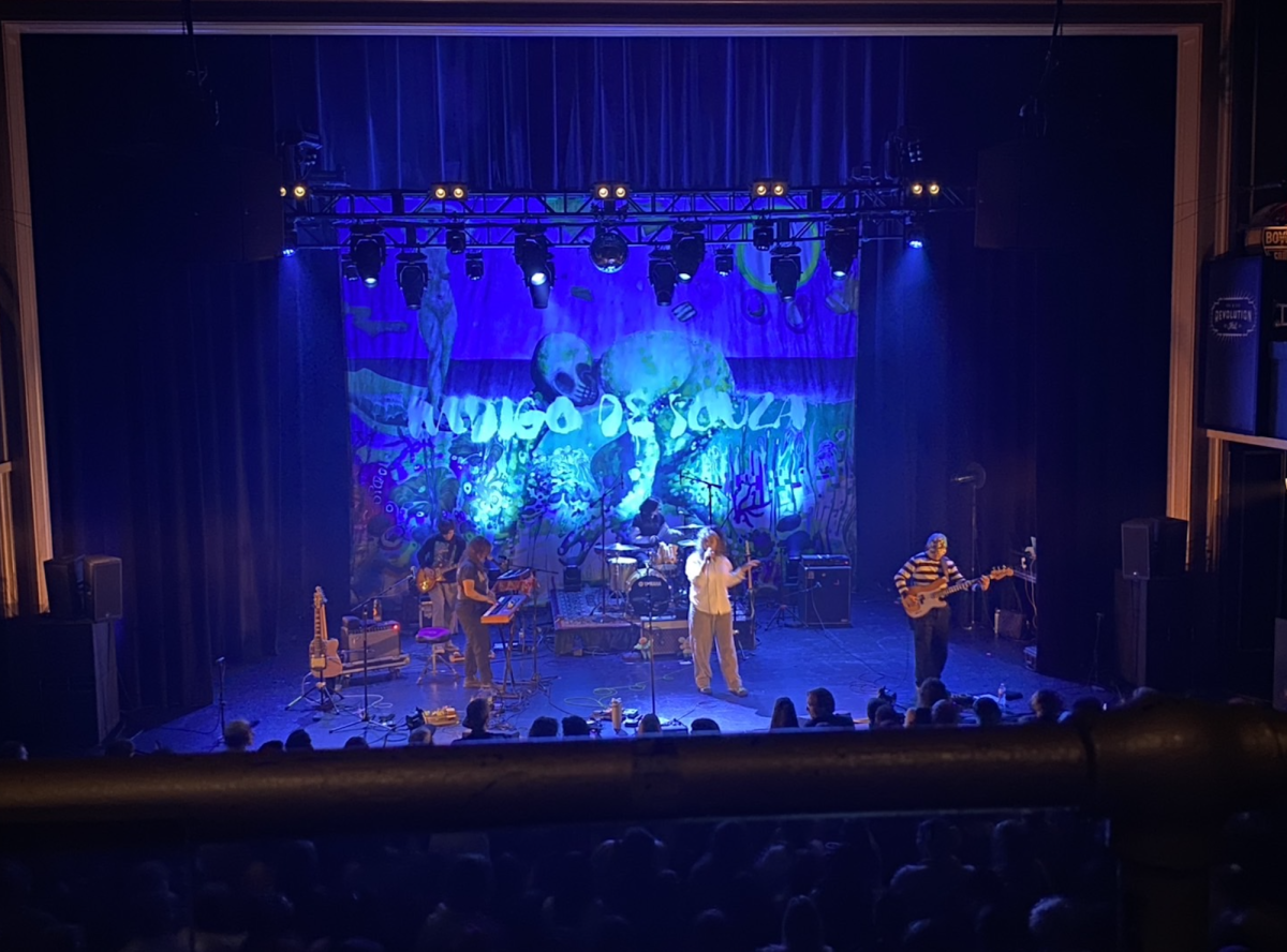 A band performs on stage lit in blue.